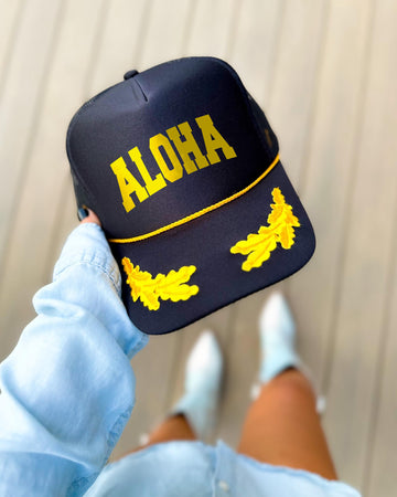 Aloha black trucker hat with gold varsity lettering, gold rope and gold oak leaves on the visor
