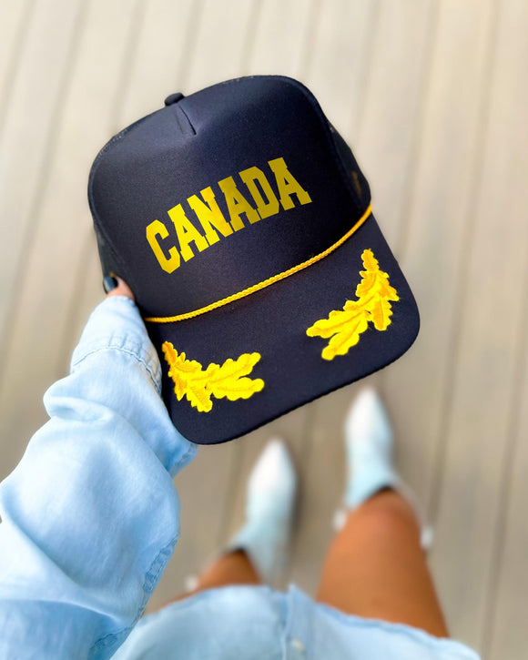 Canada black trucker hat with gold varsity lettering, gold rope and gold oak leaves on the visor