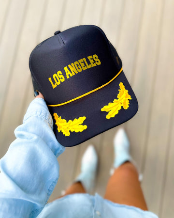 Los Angeles California black trucker hat with gold varsity lettering, gold rope and gold oak leaves on the visor